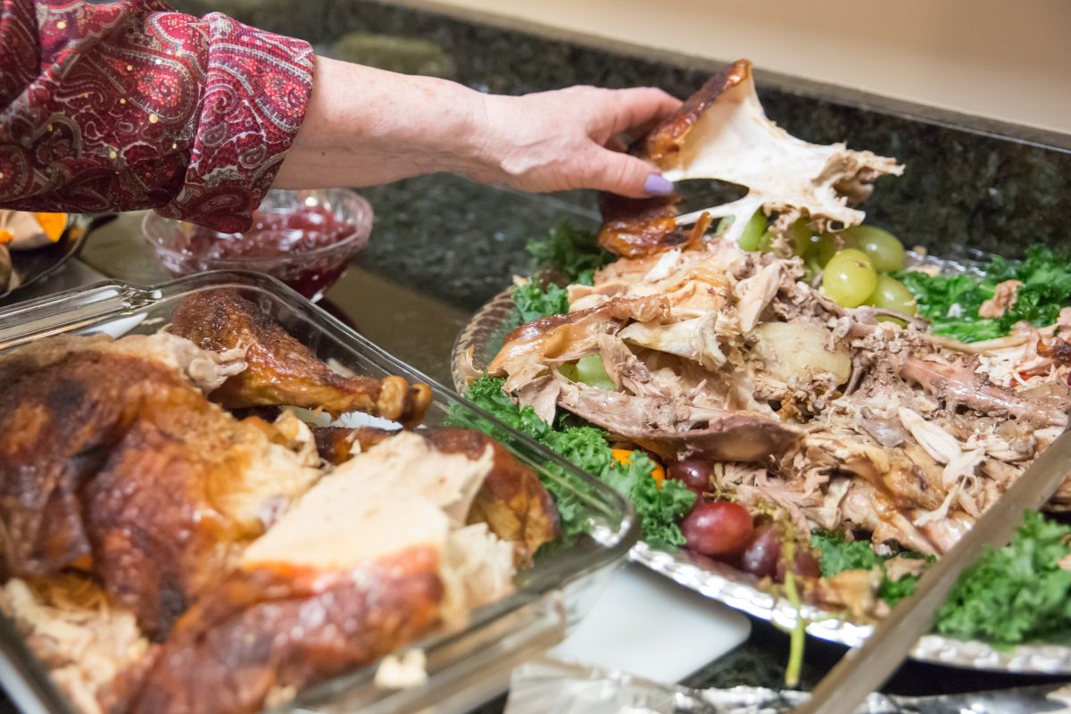 Photo of a woman's hand making leftovers into new meals.
