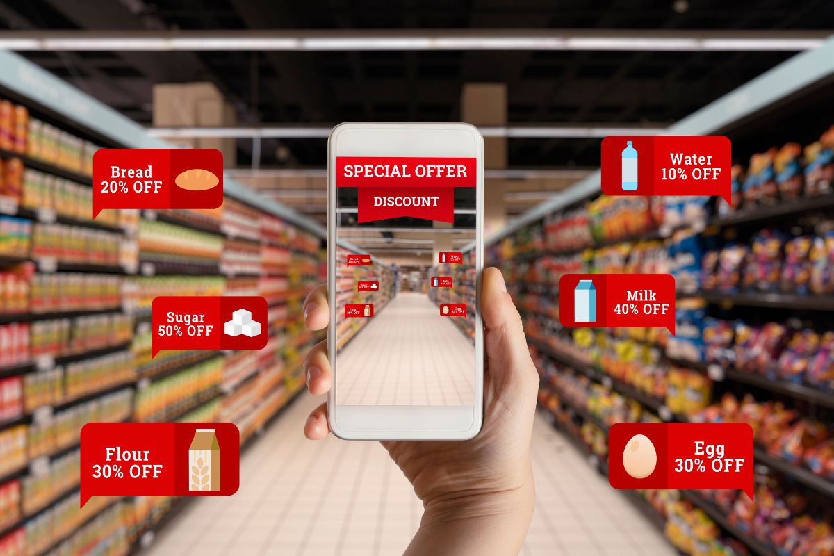 The photo tells about product displays, signages with icons and notes, and a girl's hand using a phone to take a picture of the corner which means looking for discount sections is an easy way to find deals without much effort and save a lot on groceries.