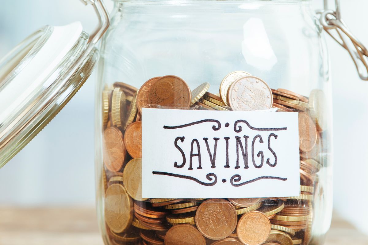 The picture shows a jar filled with coins and a note referring to automate savings helps stay consistent and remove the temptation to spend.