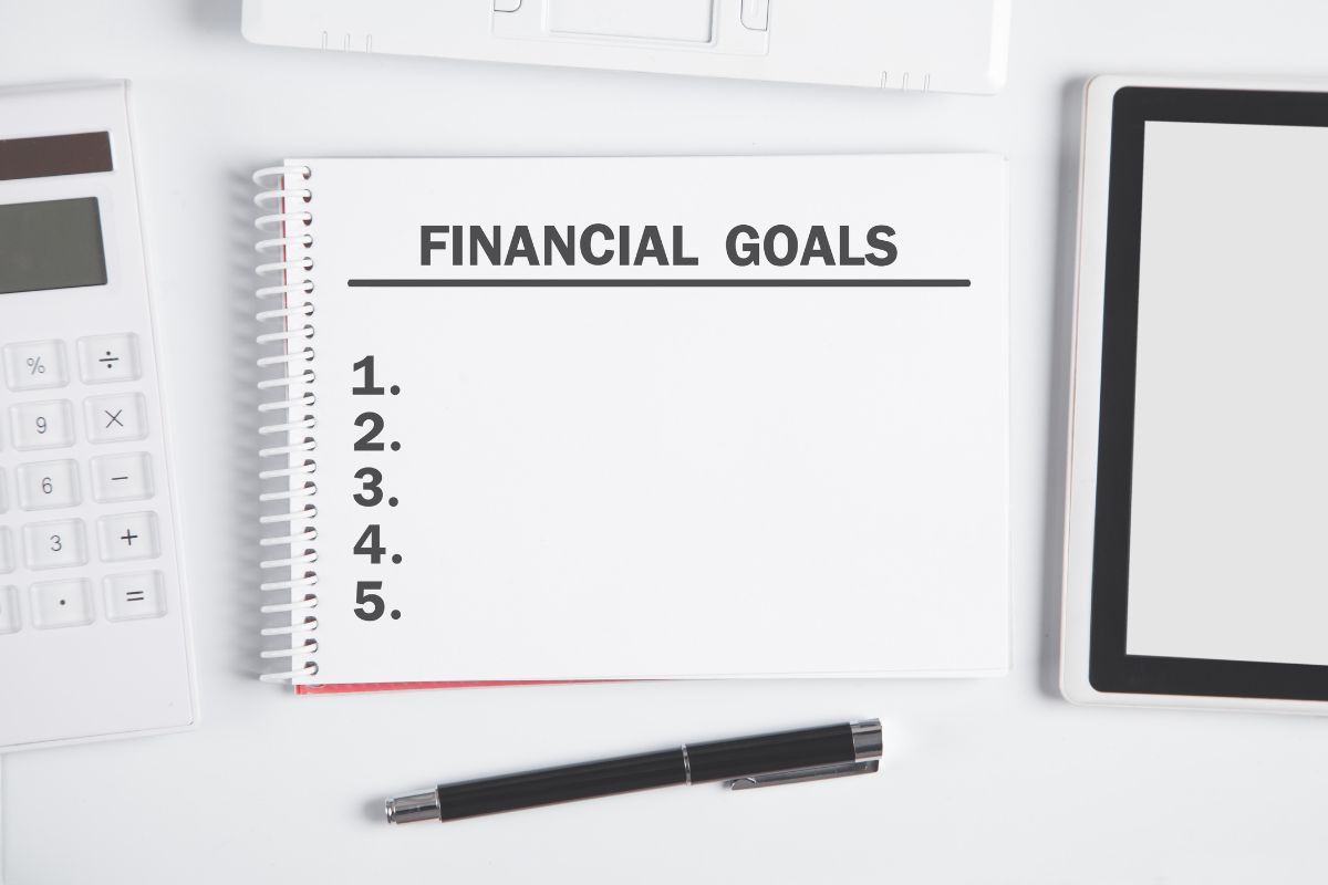 The image shows a notebook with wording for financial goals.