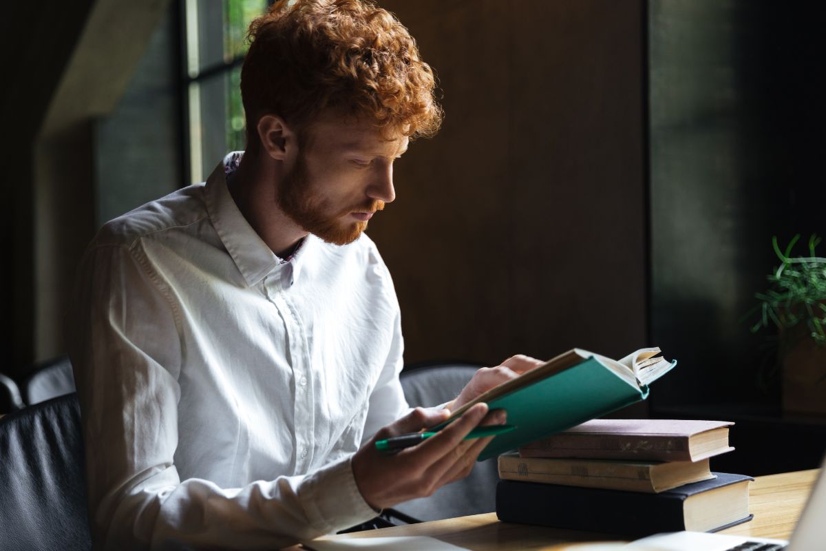 The picture shows a man reading a book.