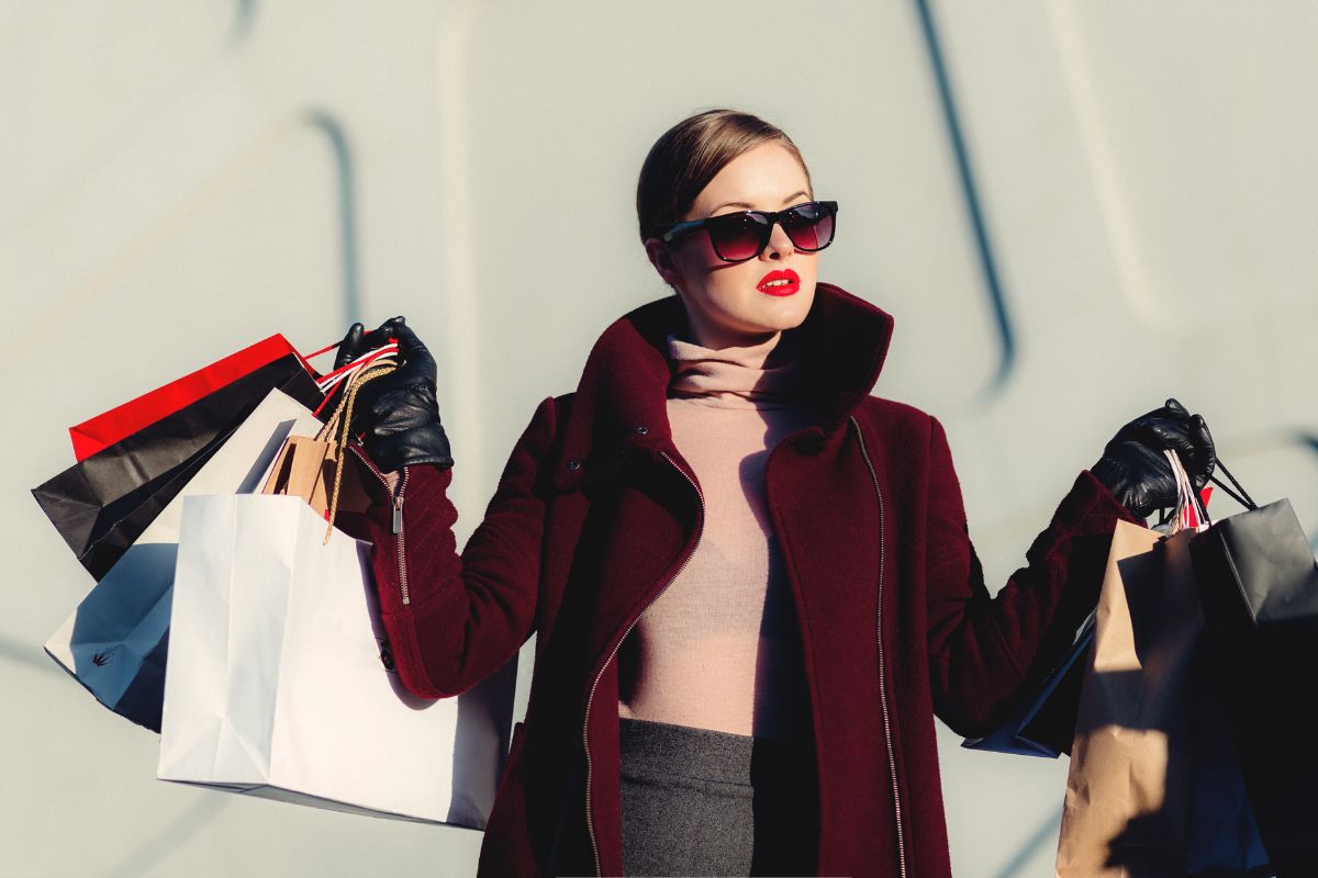 The picture shows a girl carrying shopping bags referring to avoiding impulse purchases helps avoid wasting money on things don't really need.