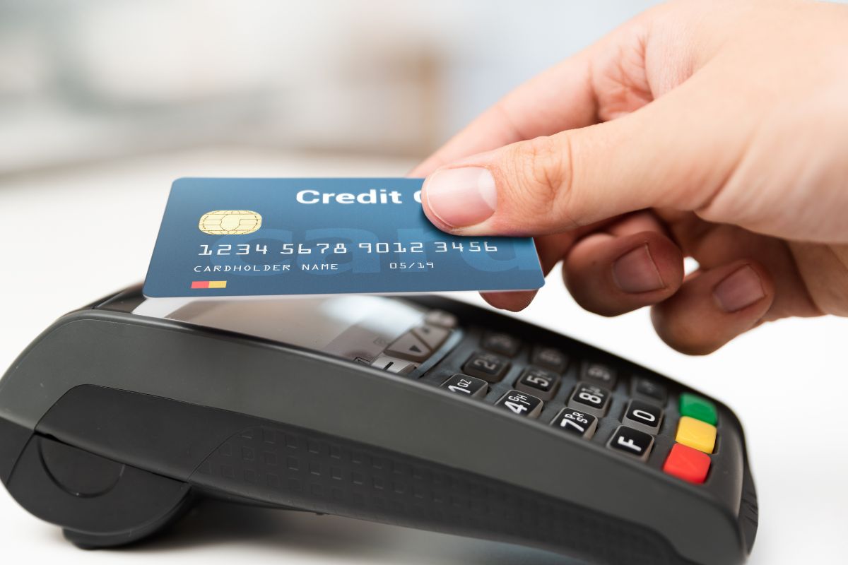 Picture of a woman's hand using a credit card.