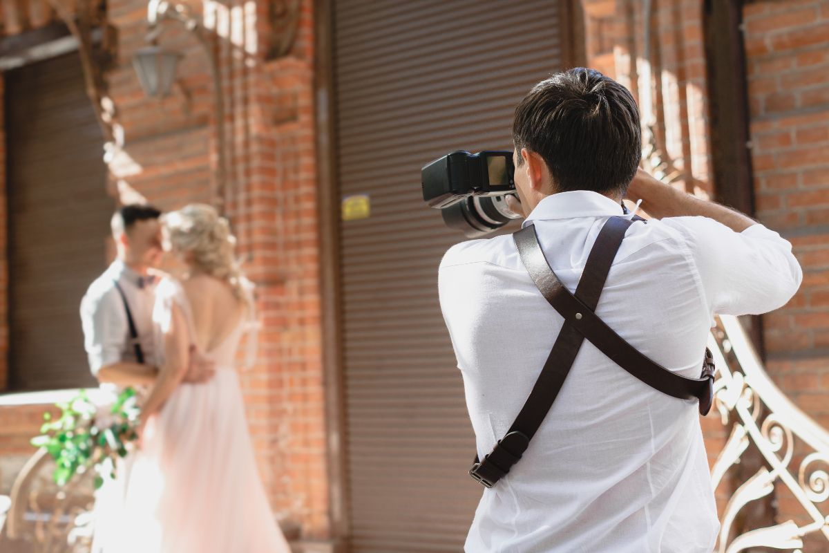 The image tells about a couple as a subject and a photographer taking them a picture indicating that monetizing hobbies is a smart way to build wealth.