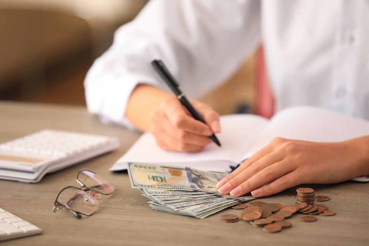 The photo shows a woman's hand budgeting.