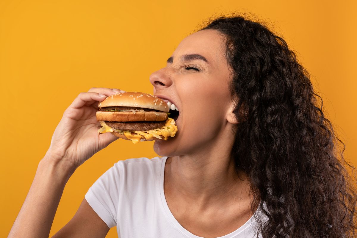 Image of a woman eating a burger as a reward.