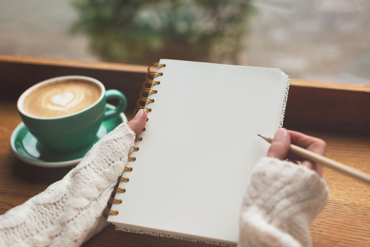 Image of a woman's hand and writing her financial goals.