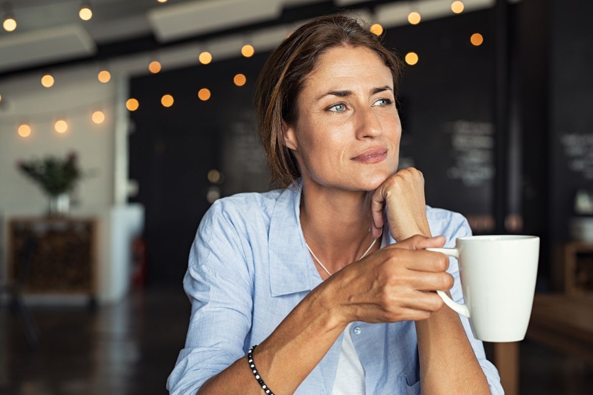 The picture tells about a girl thinking while having a coffee referring to imagining your future self leads to financial freedom later.