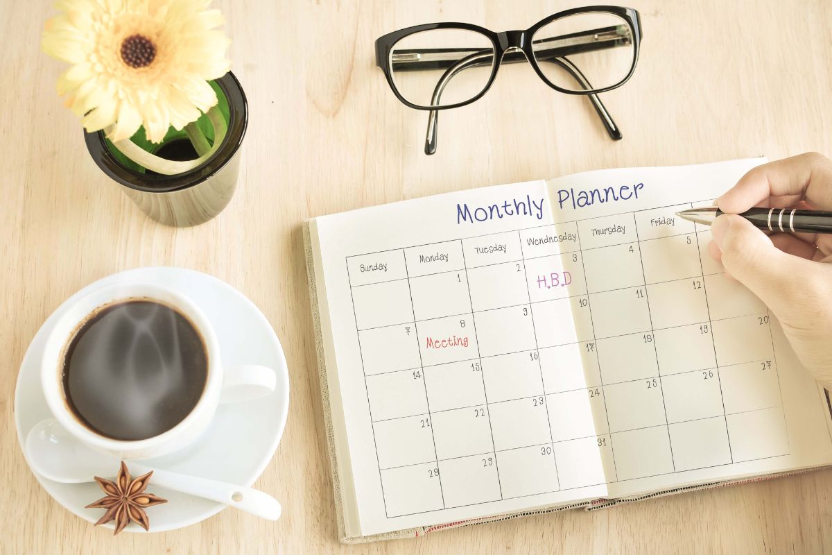Photo of a woman's hand creating a monthly planner.