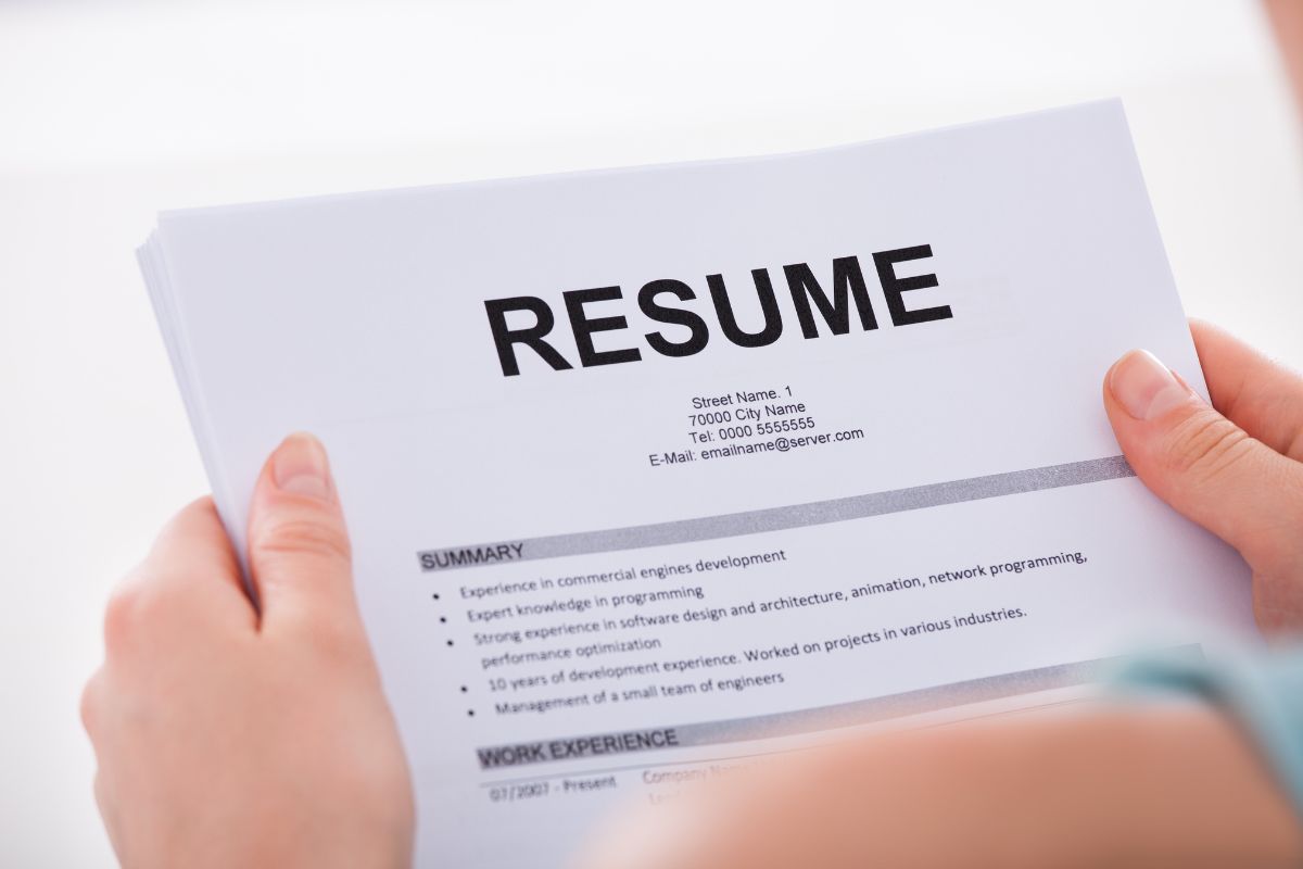 The image tells about a girl's hand holding a piece of paper with notes referring to making your resume match the job you want and making you look ready for the next step.