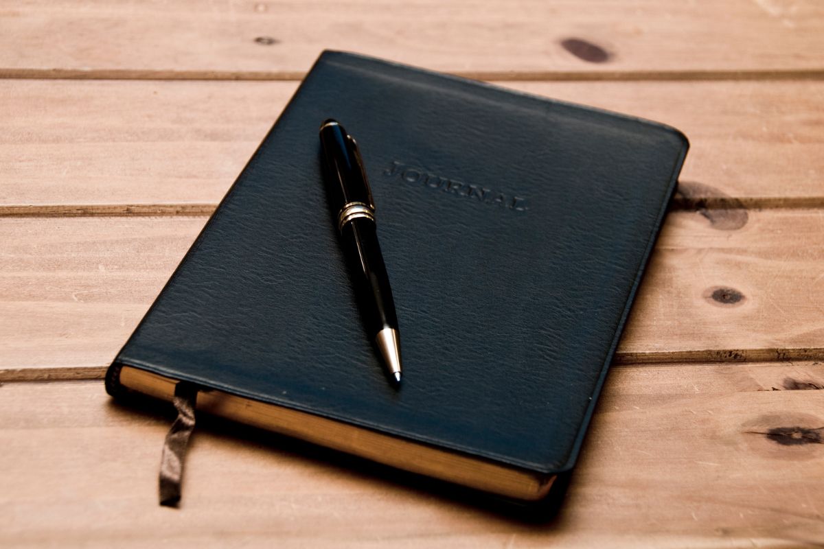 The photo shows a pen and a notebook referring to keeping a journal of career breakthroughs reminds you that you're on the right track.