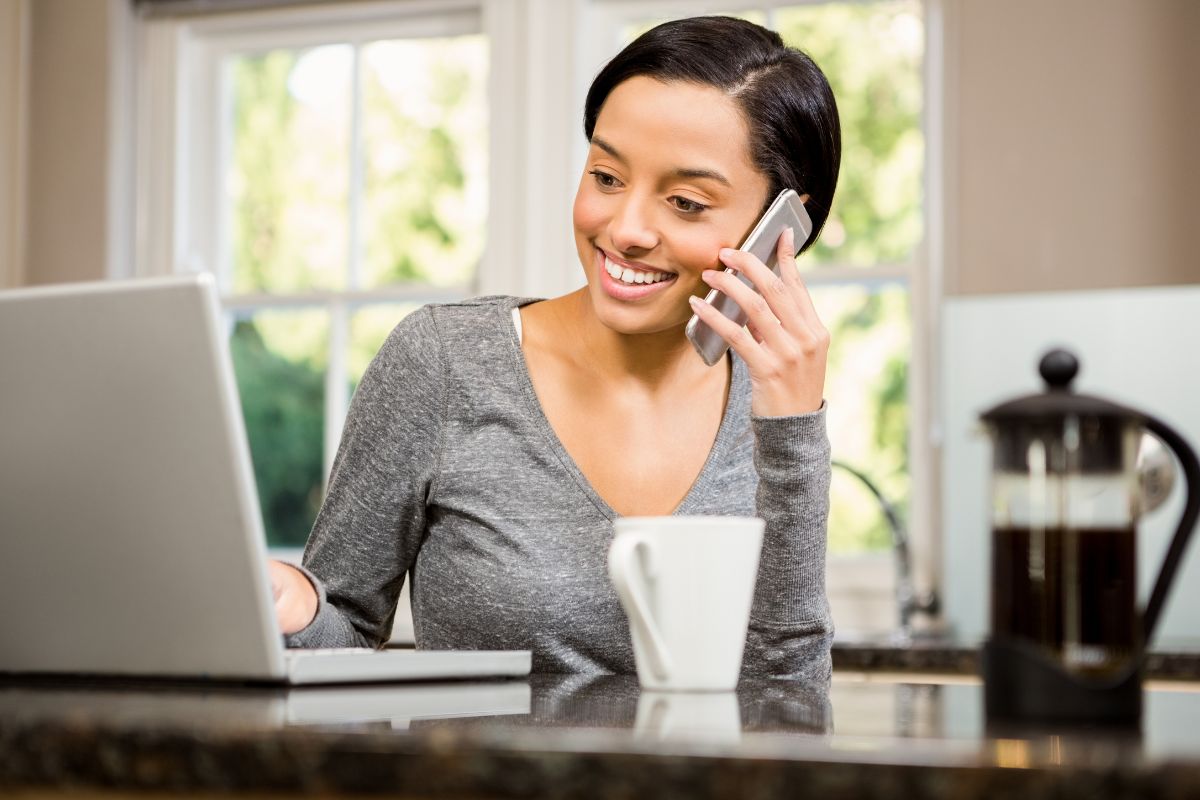 The photo tells about a mug and a girl using a laptop while on call referring to negotiating a bill that could save you a lot of money each month and can go straight into your savings.