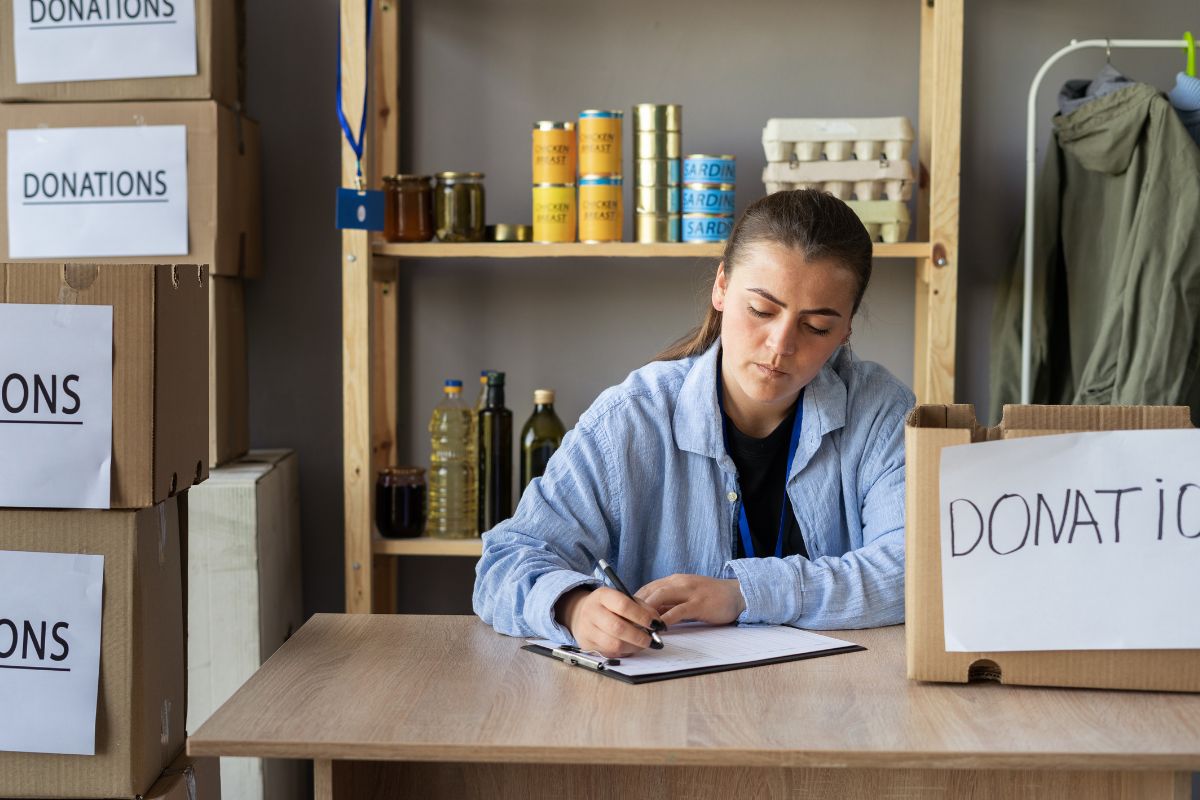 The image shows a woman and donation boxes.