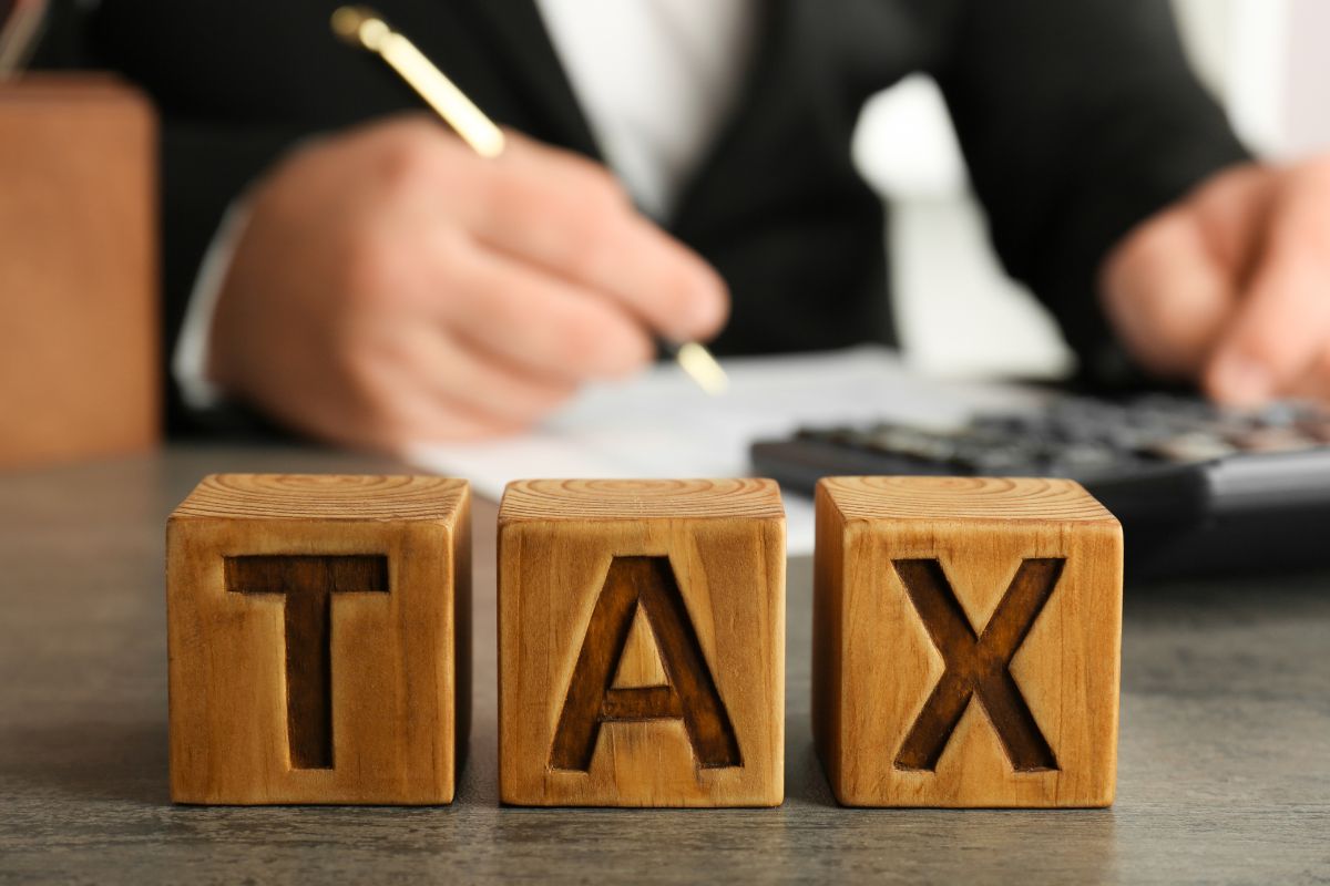 Picture of a man and tax wording on wooden cubes.