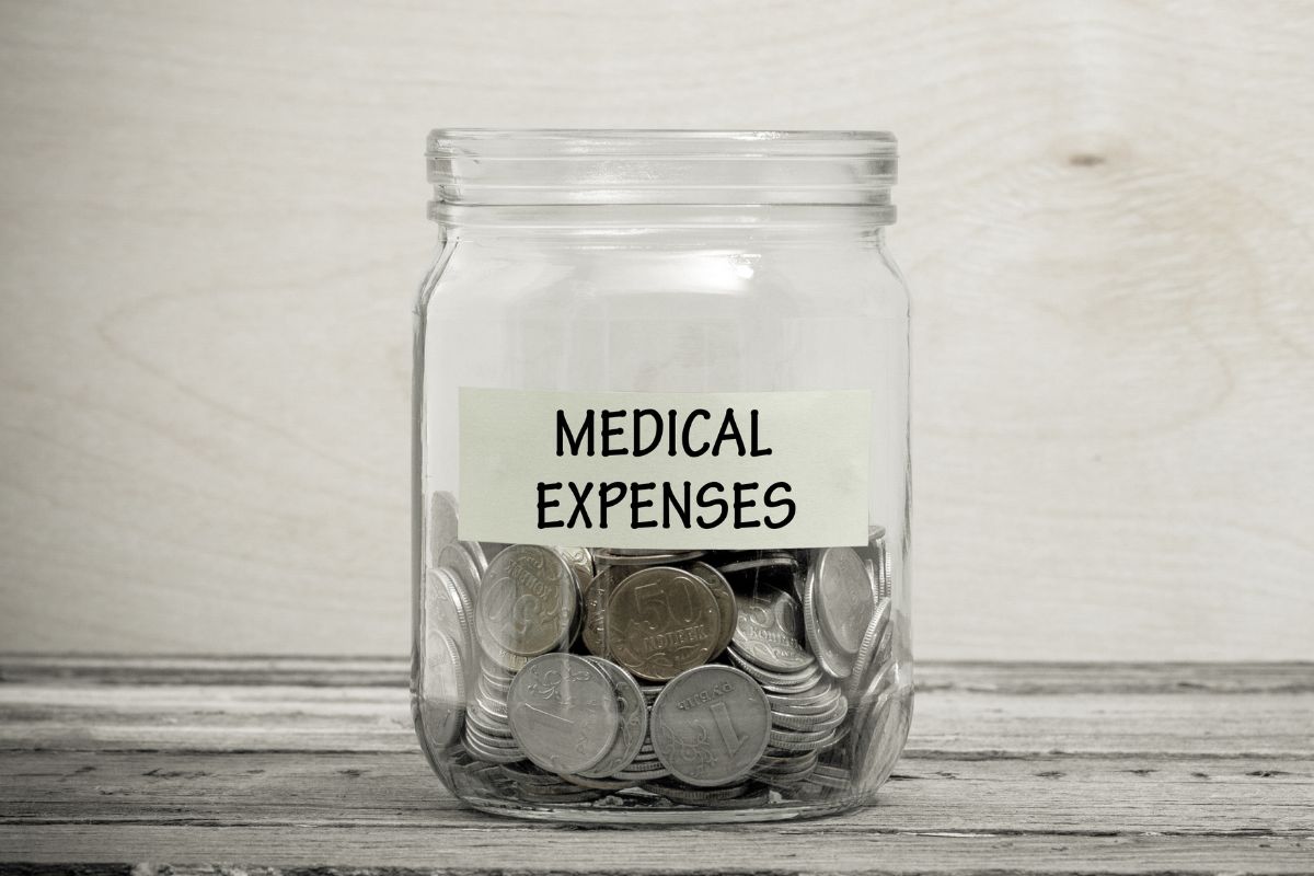 The image shows a jar filled with coins and a piece of paper with a note referring to deducting medical expenses can offer relief for those facing high healthcare expenses.