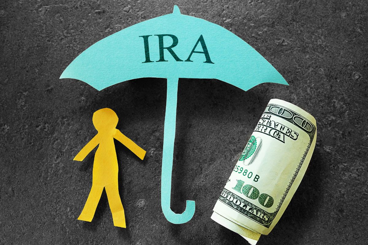 The photo tells about a rolled dollar bill, a human cut paper, and an umbrella with a note indicating that claiming a saver's credit could mean extra savings while preparing for retirement.