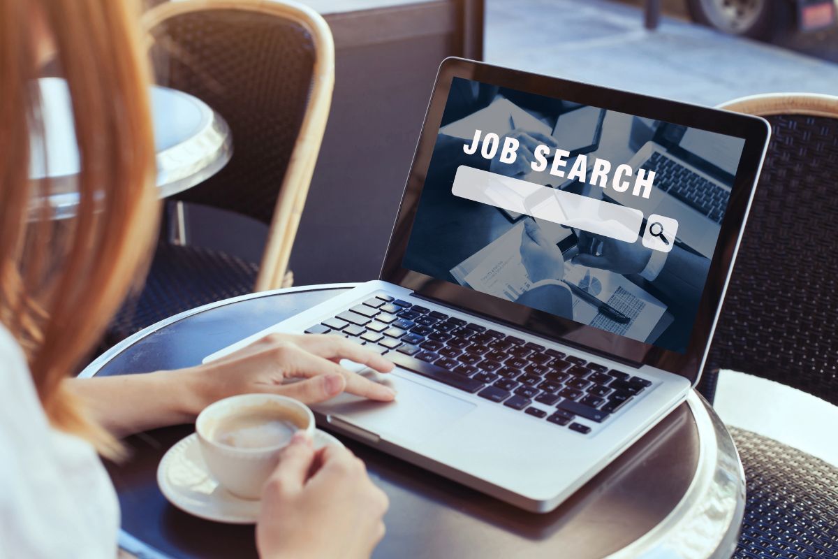 The photo shows a girl using a laptop with a screen display while having a coffee which means that keeping records of job search expenses can add up and reduce taxable income.