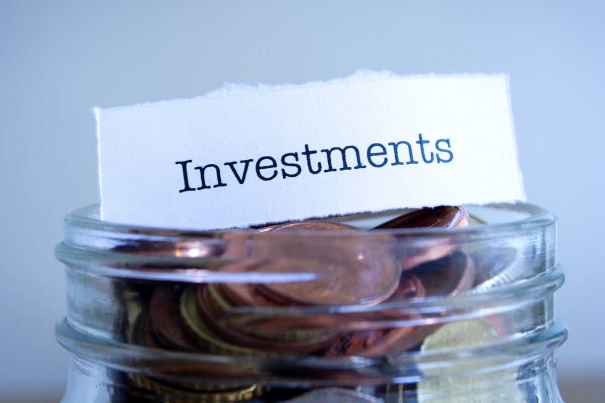 The photo shows a jar filled with coins and a piece of paper with a note indicating that deducting investment-related expenses ensures no potential savings are missed.