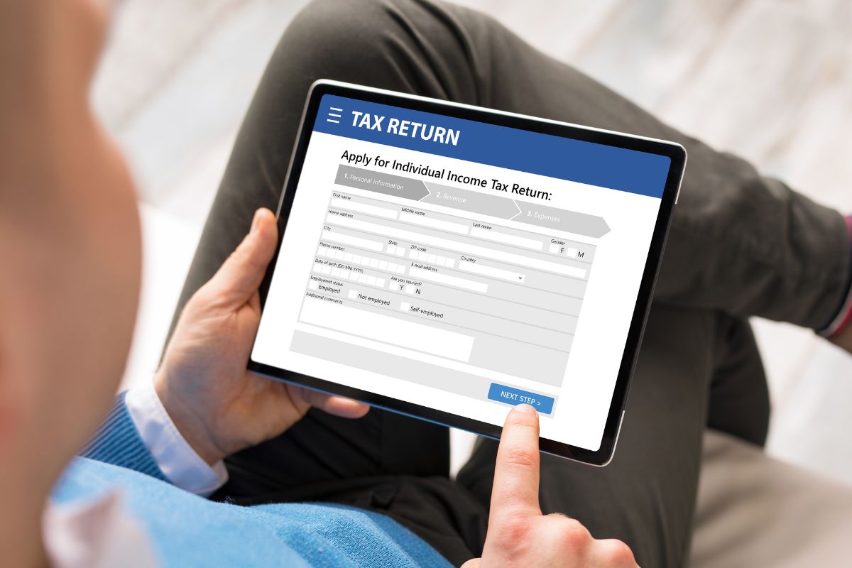 The image shows a man filing taxes online.