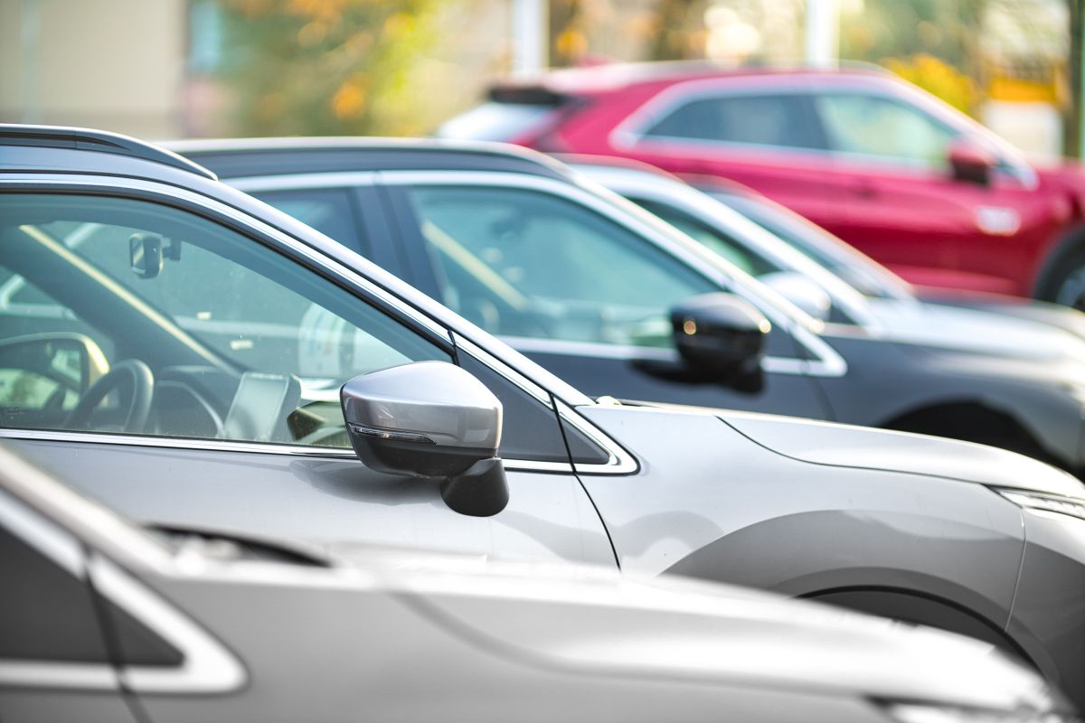 The Image tells about cards in the parking area referring to used cars with cash means no monthly payments or interest stacking up.