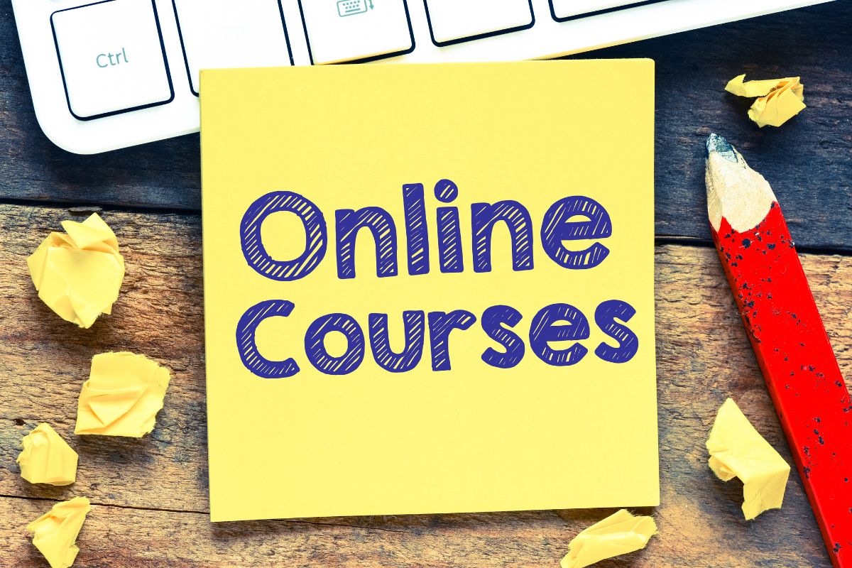 The photo shows a pen, crumpled papers, a keyboard, and a piece of paper with notes which means creating and selling online courses and making money online from home without needing to trade hours for pay.