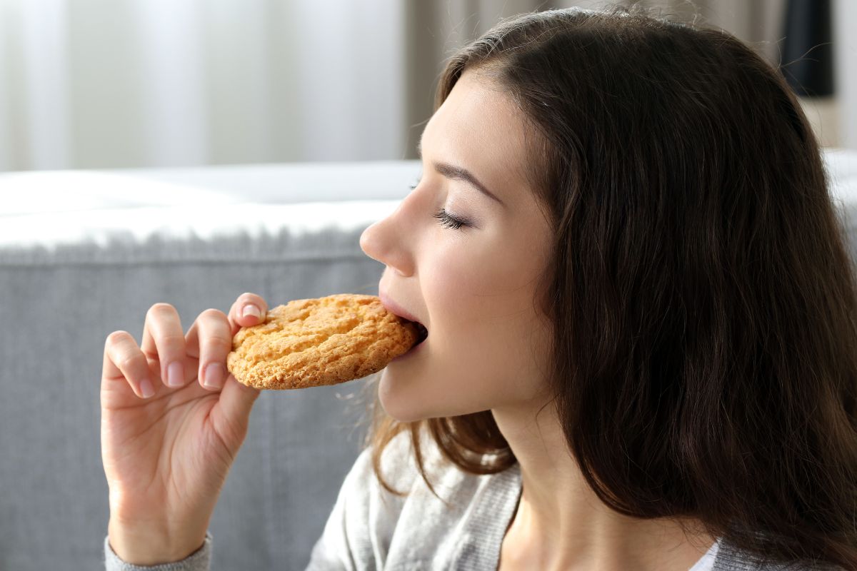 The photo shows a girl eating a cookie referring to trying the pantry-challenge to save money by skipping a week of groceries while clearing out items that might go to waste.