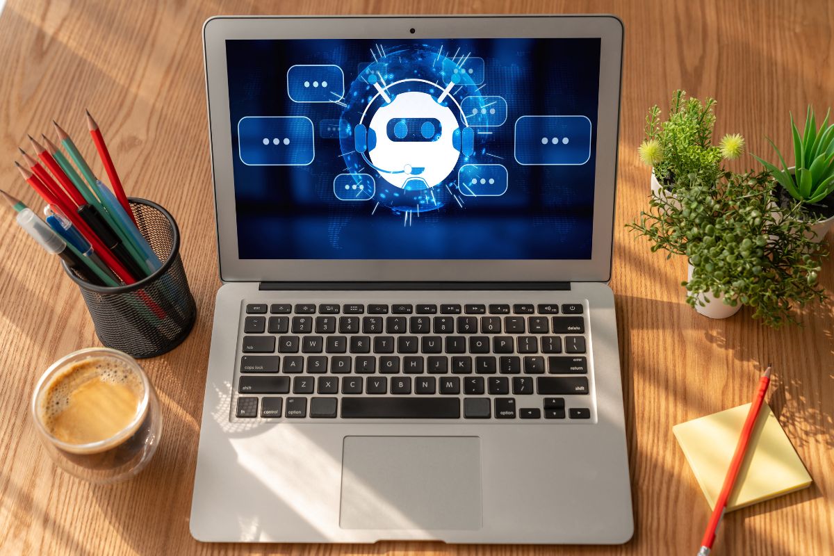 The photo shows plants, pens, a coffee, a sticker note, and a laptop with a screen display referring to the offer of AI automation consulting for small businesses is a way to make money online while helping businesses grow.