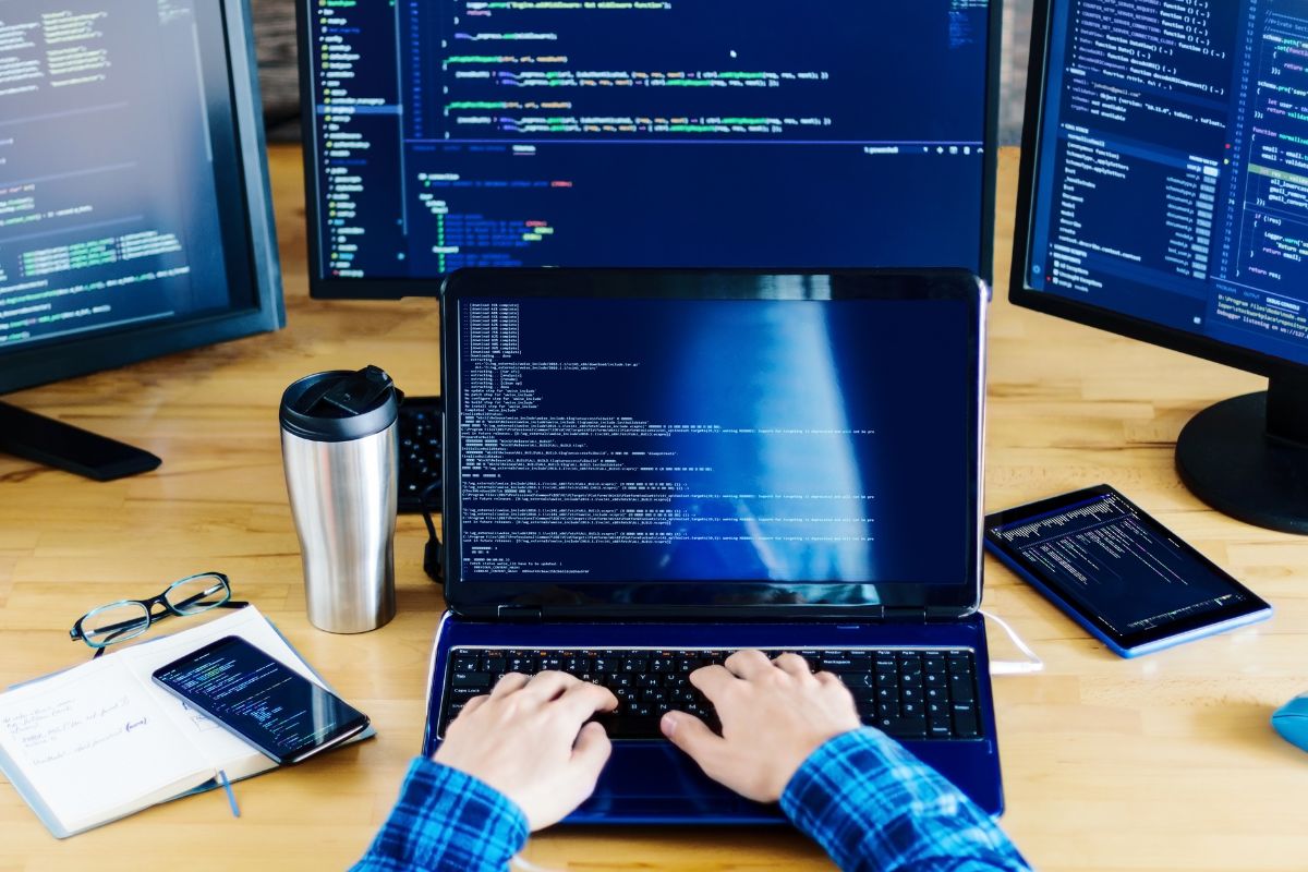 Image shows a man's hand coding.
