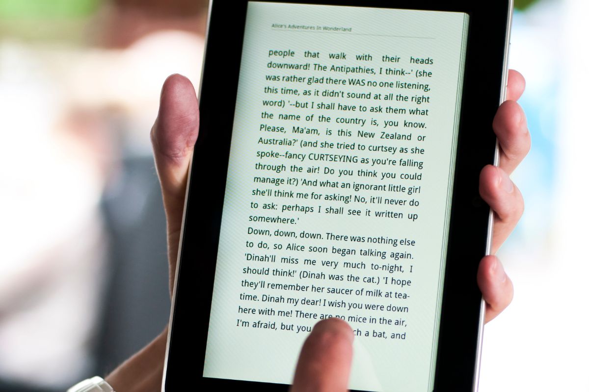 The image tells about a man's hand holding a tablet device with texts referring to self-published high-quality Ebooks as a good option for making money in your spare time with creative work.