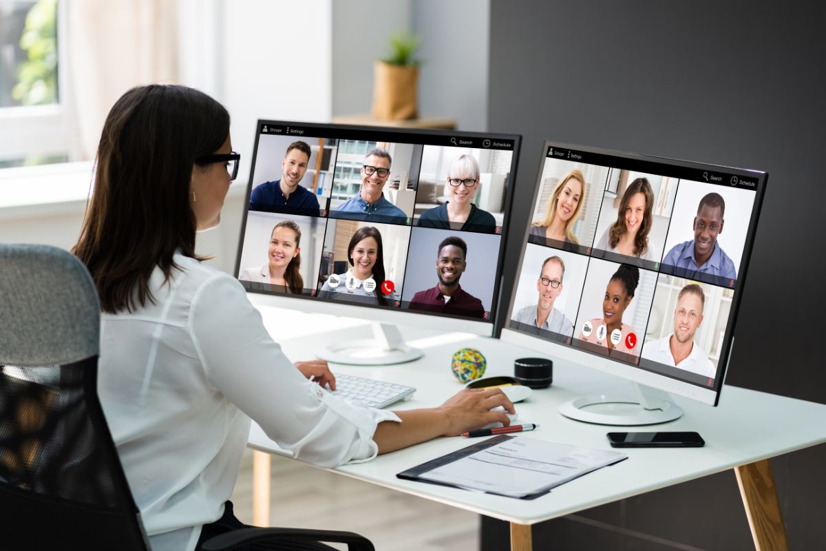 The image shows papers on the table, a phone, and a girl having an online call with people on the screen referring to starting a paid mastermind group for professionals is a good way to make money remotely and can be a steady income source.