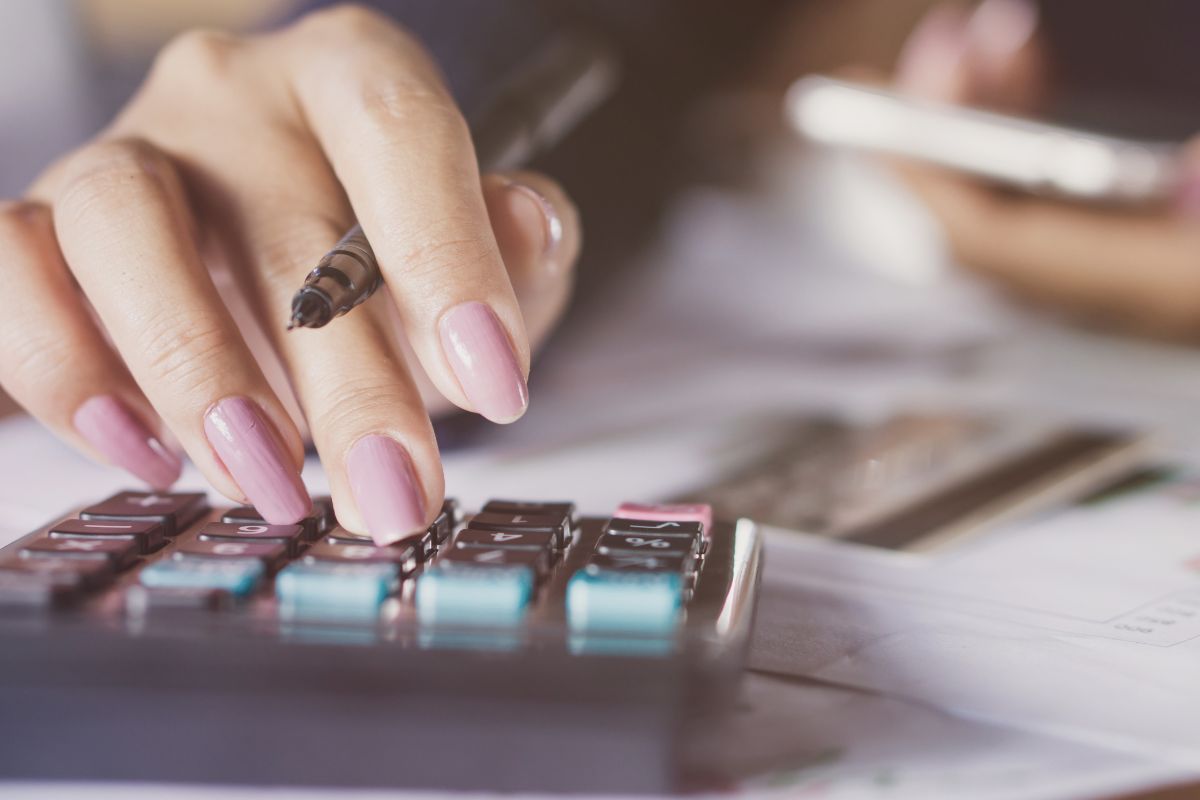 An image shows a woman calculating her debt.