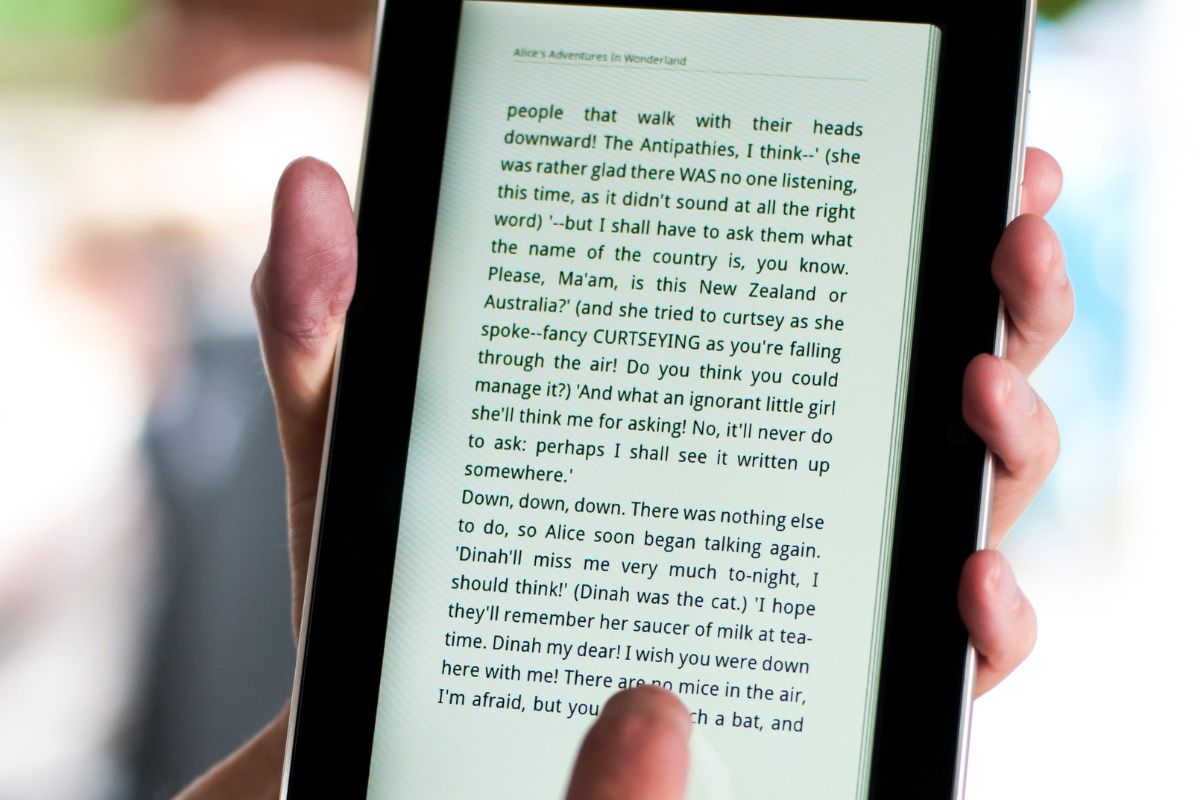 The photo shows a man's hand publishing an eBook.