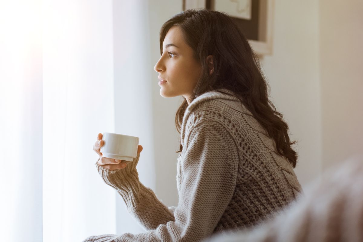 The picture shows a woman having a coffee.