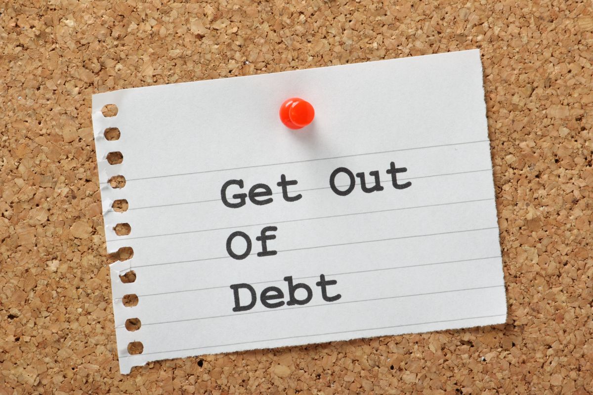 The photo shows a paper with the Get out of Debt wording.