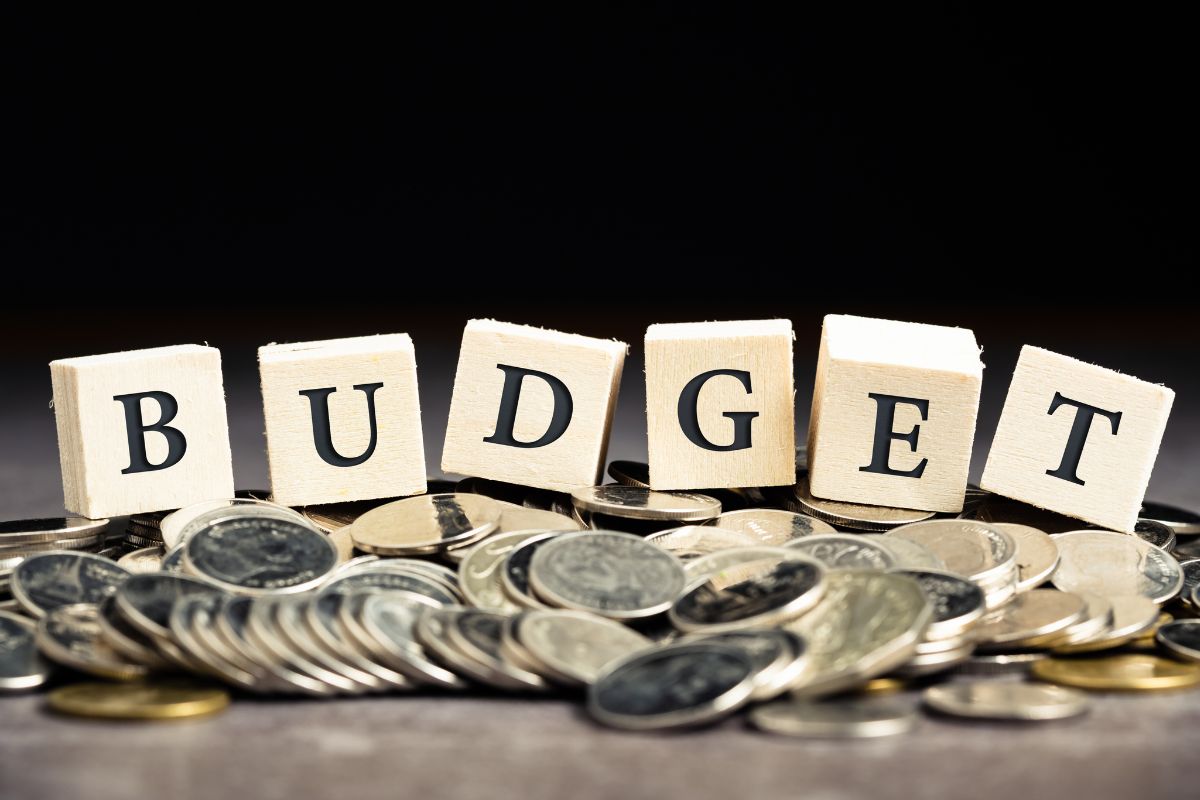 The photo shows coins and budget wording.