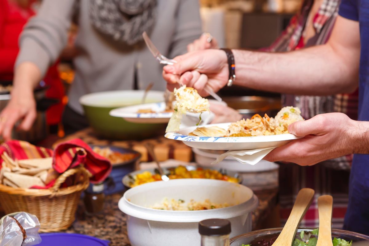 The photo shows a group of people hosting potlucks.