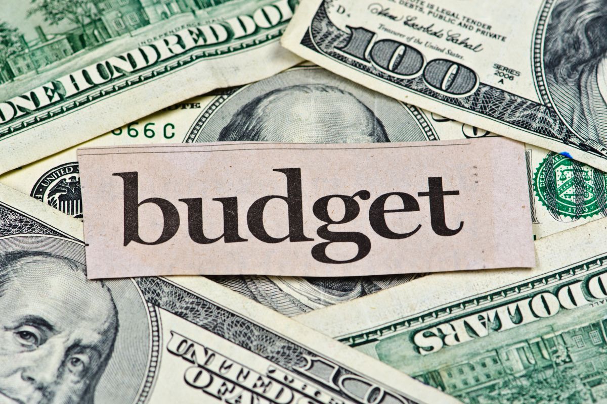 Photo of money and a paper with budget wording.