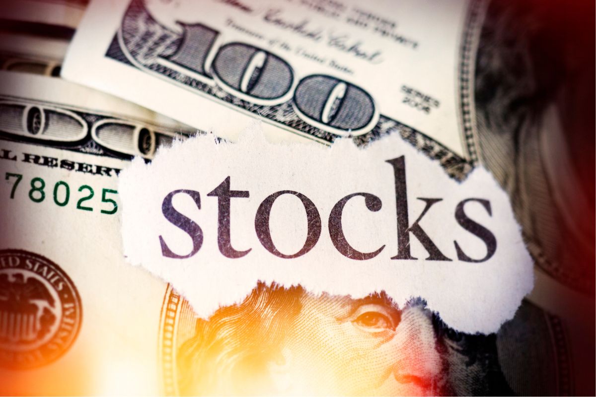 The photo shows money and a paper with stock wording.