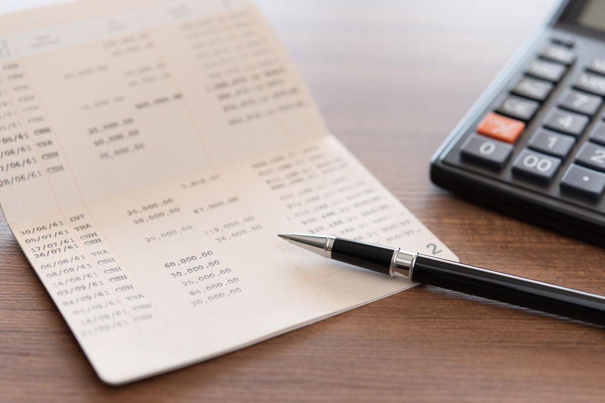 The picture tells about a calculator, a pen, and a booklet with numbers referring to setting up a separate debt payoff bank account makes it easier to build momentum.
