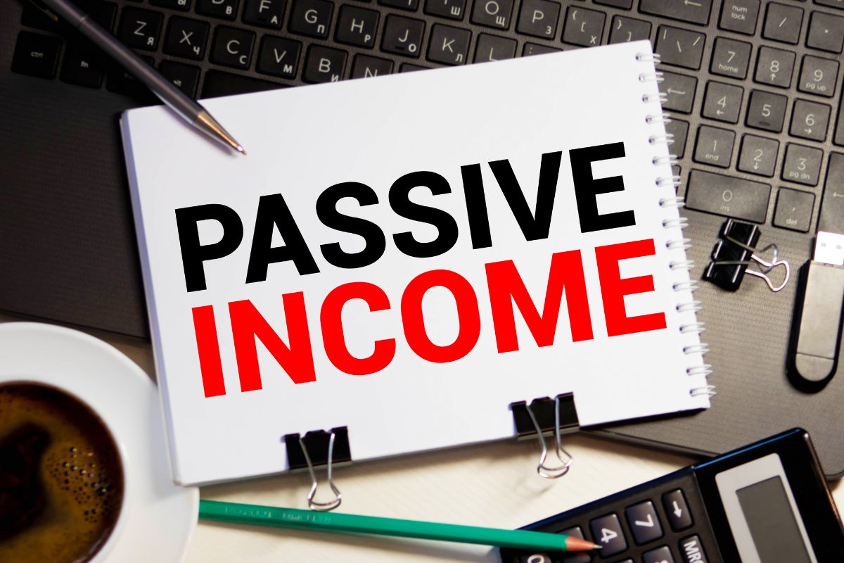 The photo shows a notebook with passive income wording.