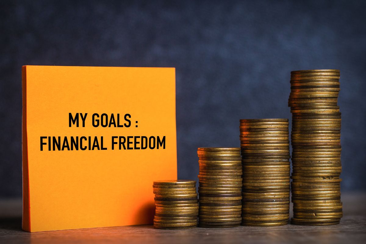 The image shows coins and a paper with financial goals wording.