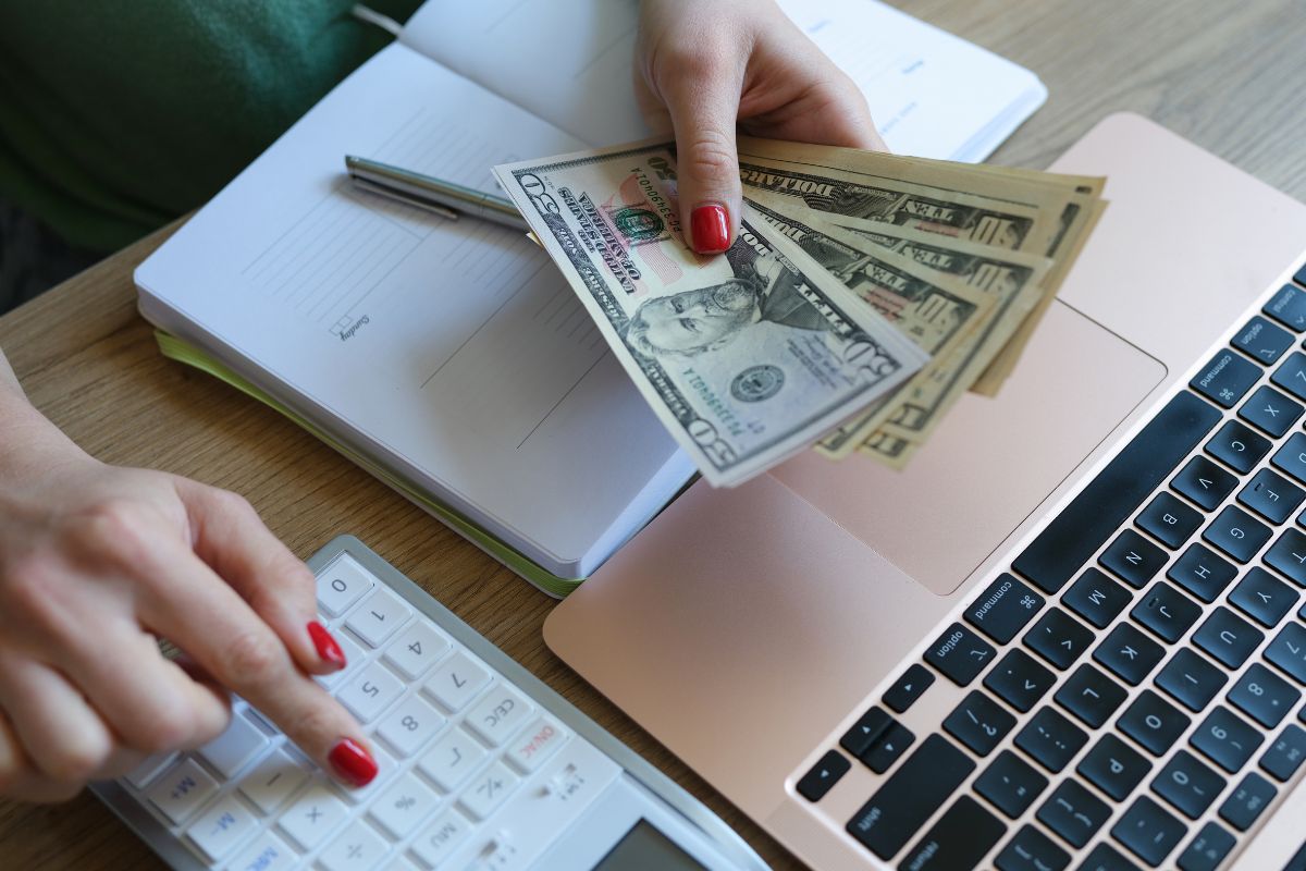 A photo shows a woman's hand tracking her money.