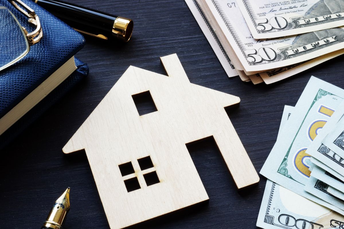 The image shows money and a house figure.