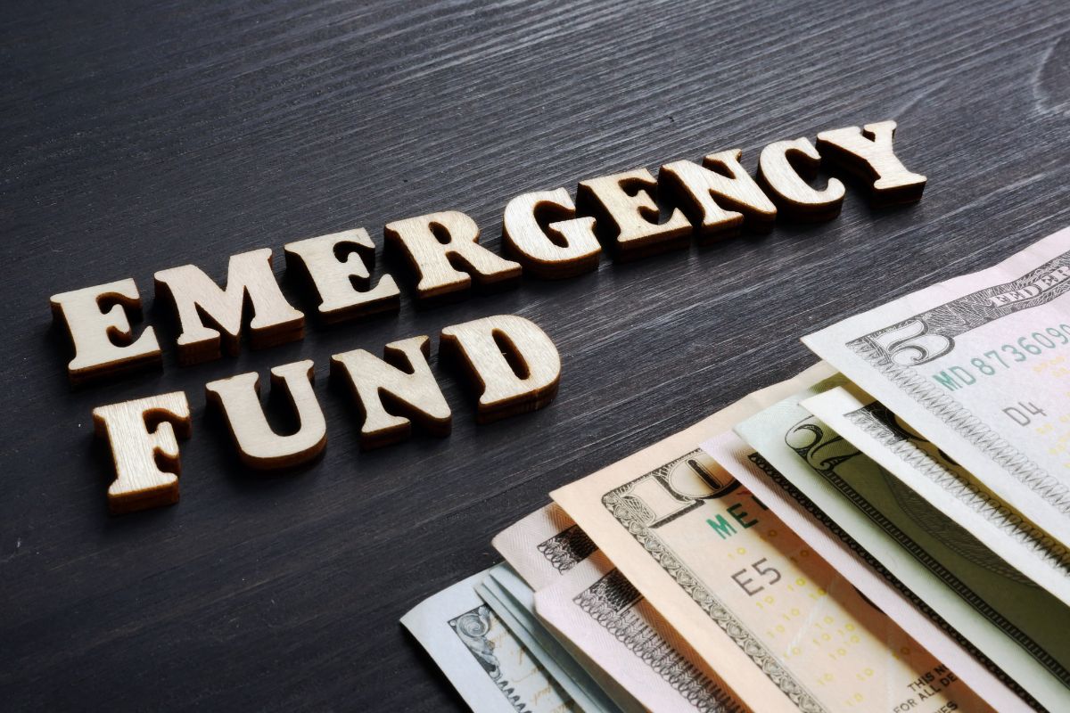The photo shows money and emergency fund wording.