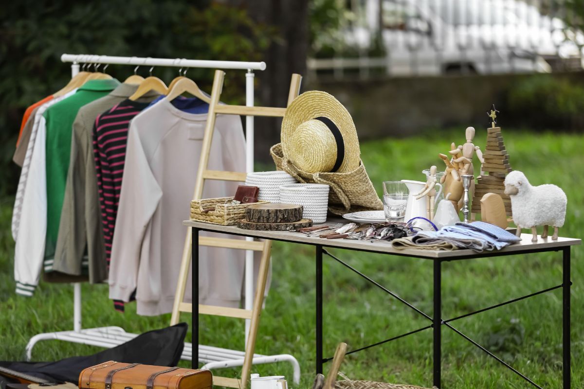 The picture shows different stuff on the table and clothes which refers to selling unused items can turn into extra debt payments and an easy way to find money without changing your budget.