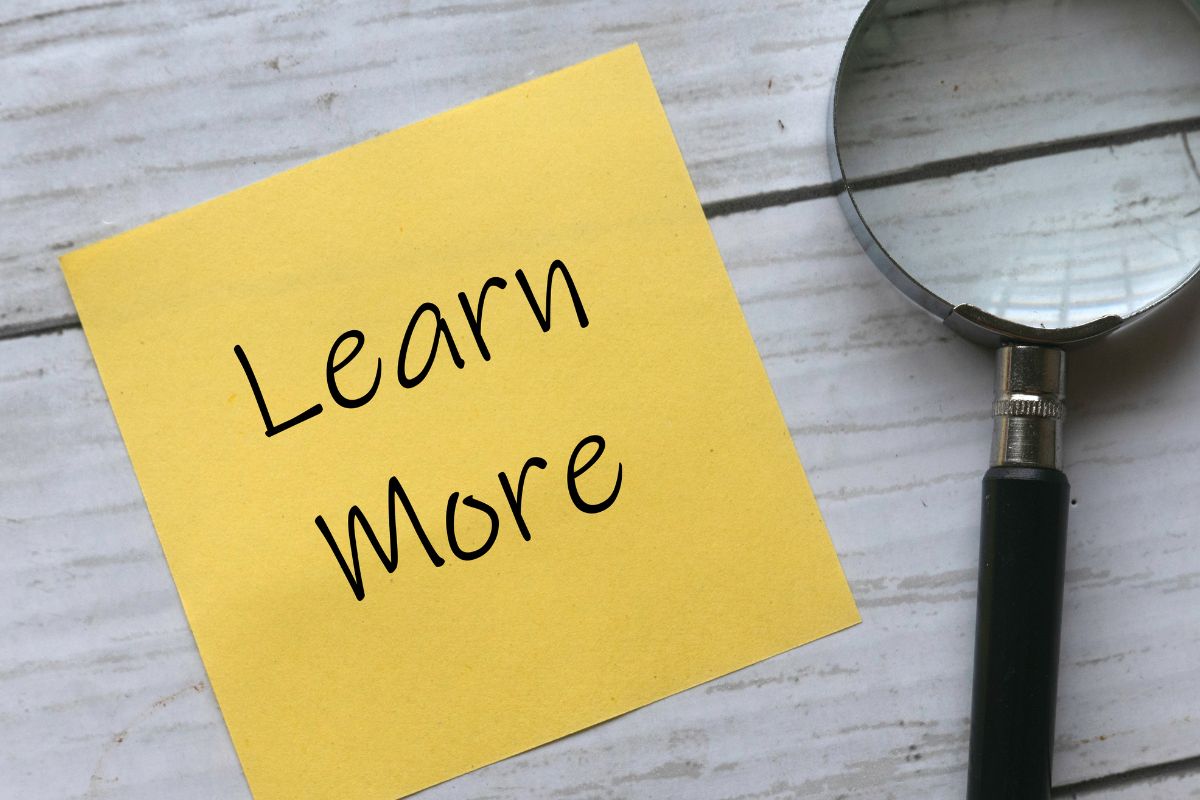 An image of a magnifying glass and a paper with learn more wording.