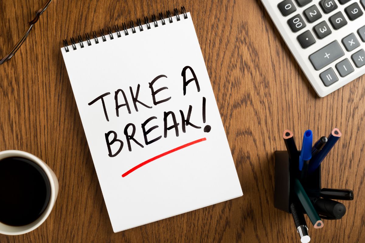 The image tells about a calculator, a coffee, pens, and a notebook with a note which means that a spending detox week can help break bad habits and kickstart better money choices.
