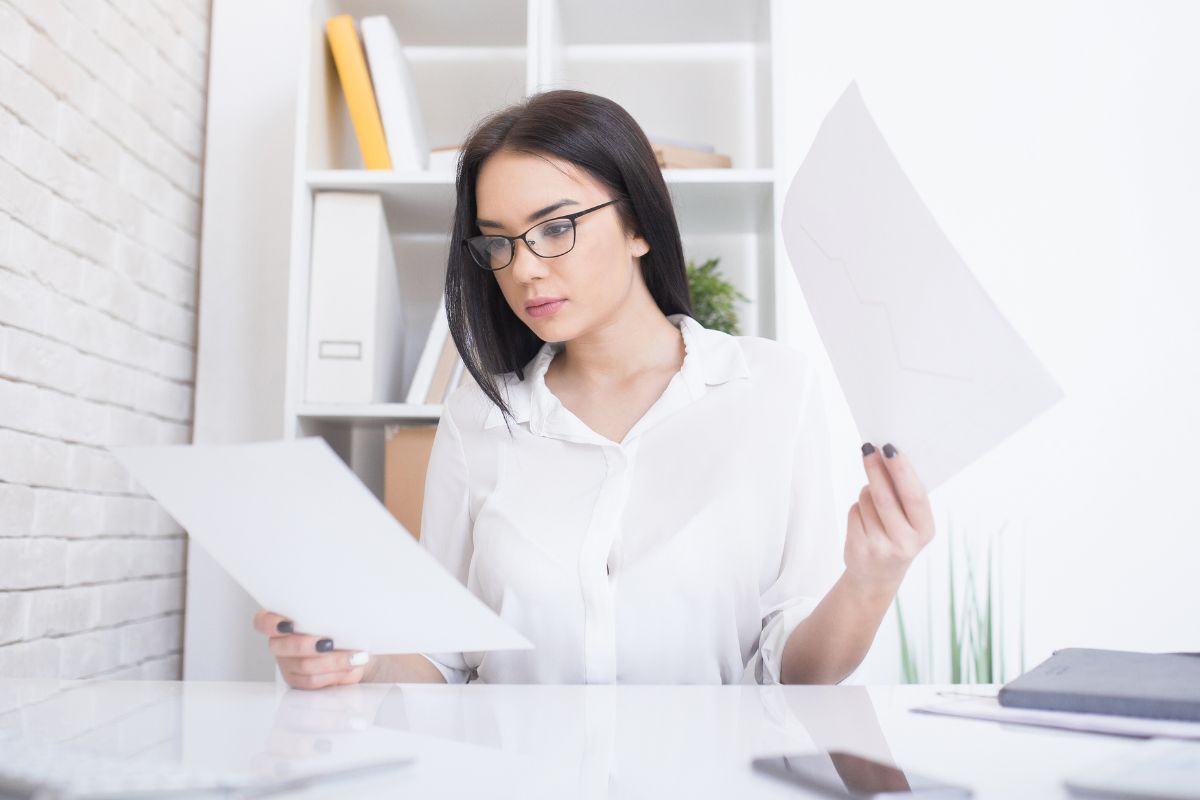 The photo shows a girl looking at the papers which means analyzing trends and adjusting habits helps you see where to improve.