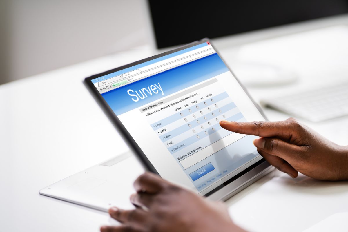 The photo shows a girl's hand using a laptop with a screen display which means participating in online surveys is an easy way to earn extra money with little effort.