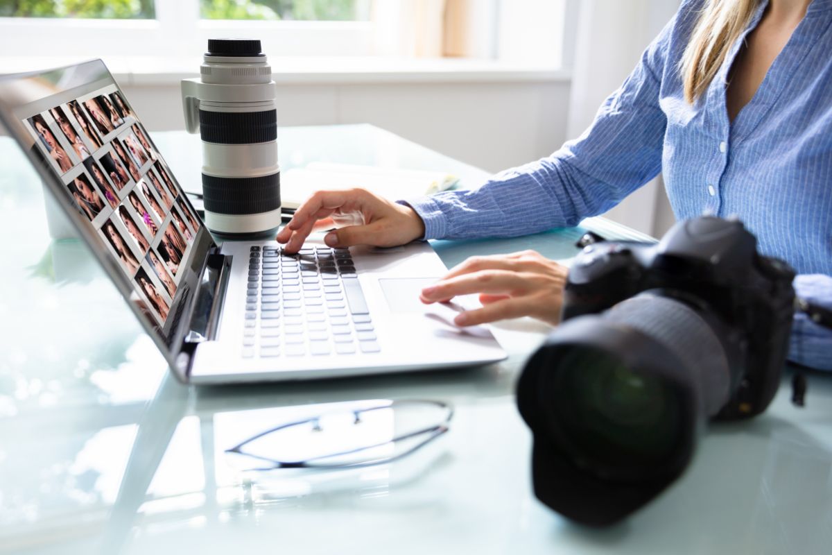 The picture shows a camera, an eyeglass, and a girl using a laptop which means selling stock photos on platforms is an easy way to make passive income.